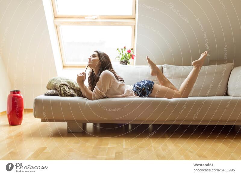 Entspannte Frau auf Couch liegend weiblich Frauen Sofa Couches Liege Sofas liegt Erwachsener erwachsen Mensch Menschen Leute People Personen Fenster entspannt