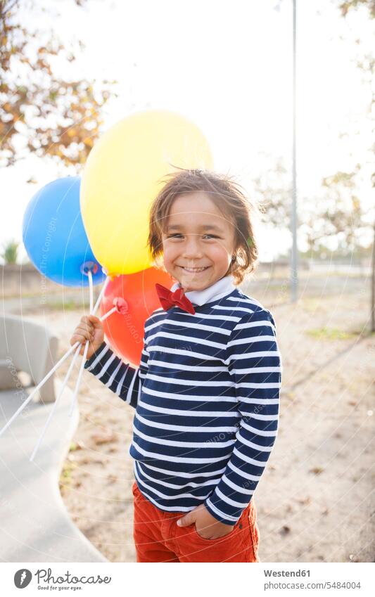 Porträt eines glücklichen kleinen Jungen mit Luftballons Europäer Kaukasier Europäisch kaukasisch lächeln Freude freuen Dreiviertelansicht Vorderansicht frontal