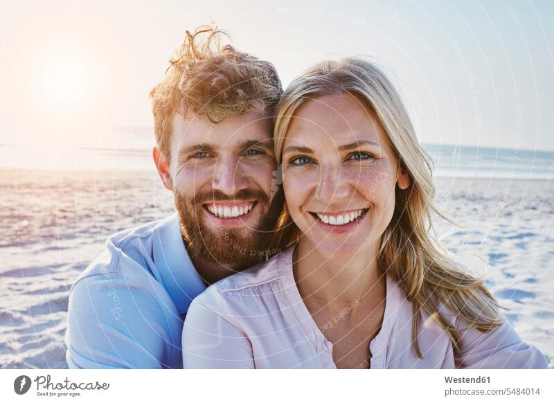 Porträt eines glücklichen Paares am Strand Beach Straende Strände Beaches lächeln Pärchen Partnerschaft Glück glücklich sein glücklichsein Mensch Menschen Leute