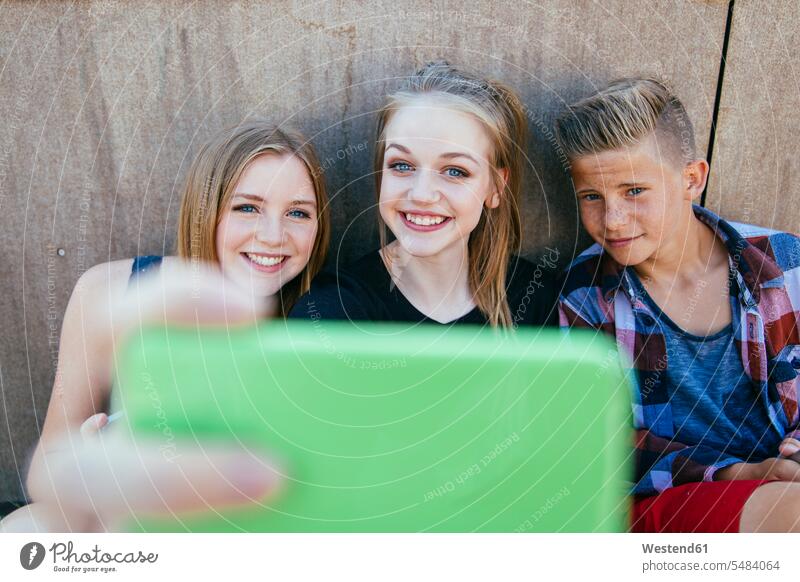Drei Teenager machen im Freien ein Selfie Jugend Freizeitkleidung casual Freizeitbekleidung Selfies Vergnügen genießen freuen Amüsement Freude vergnügt
