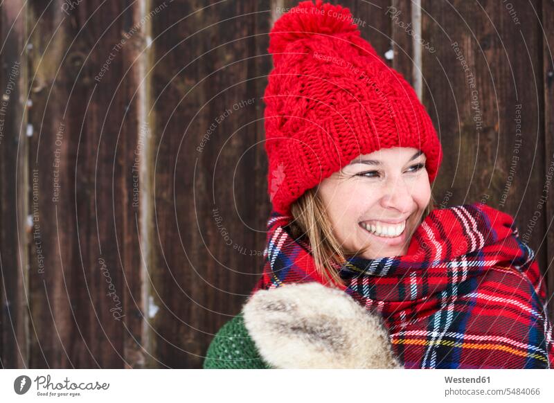 Porträt einer lächelnden Frau mit rotem Pudelhut im Winter Portrait Porträts Portraits lachen weiblich Frauen positiv Emotion Gefühl Empfindung Emotionen