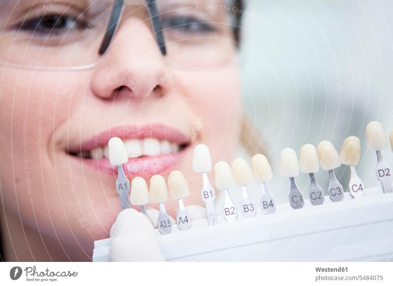 Frau beim Zahnarzt wählt Farbe für Zahnaufhellung lächeln Zähne weiblich Frauen Zahnarztpraxis Zahnarztpraxen Mensch Menschen Leute People Personen Erwachsener