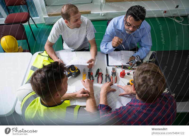 Elektriker-Lehrer sitzt mit Studenten am Tisch Ausbildung Lehrstelle Auszubildender lernen unterrichten Erziehung erzieht unterrichtend unterrichtet erziehend
