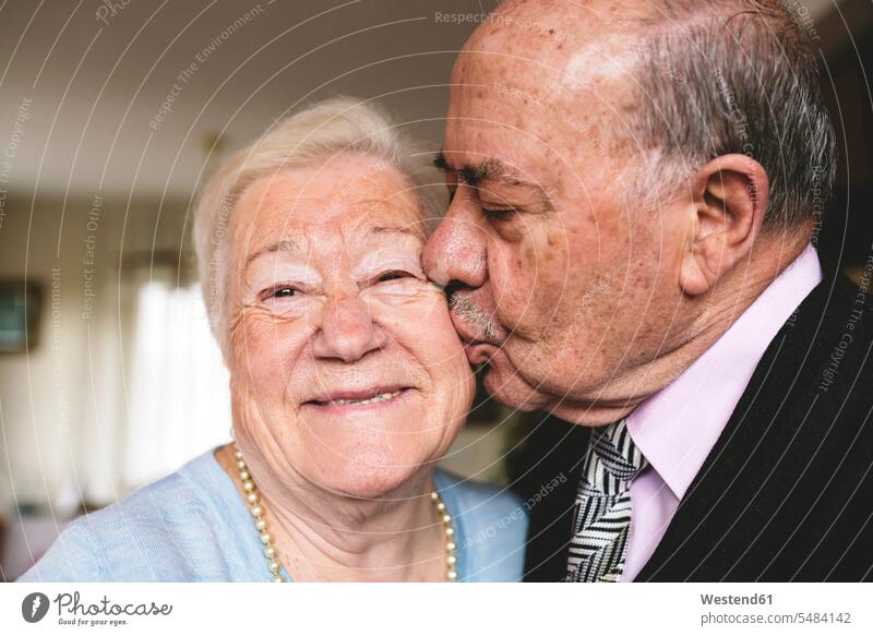 Älterer Mann küsst seine glückliche Frau Europäer Kaukasier Europäisch kaukasisch Heterosexuelles Paar Heterosexuelle Paare Mann und Frau Männer und Frauen