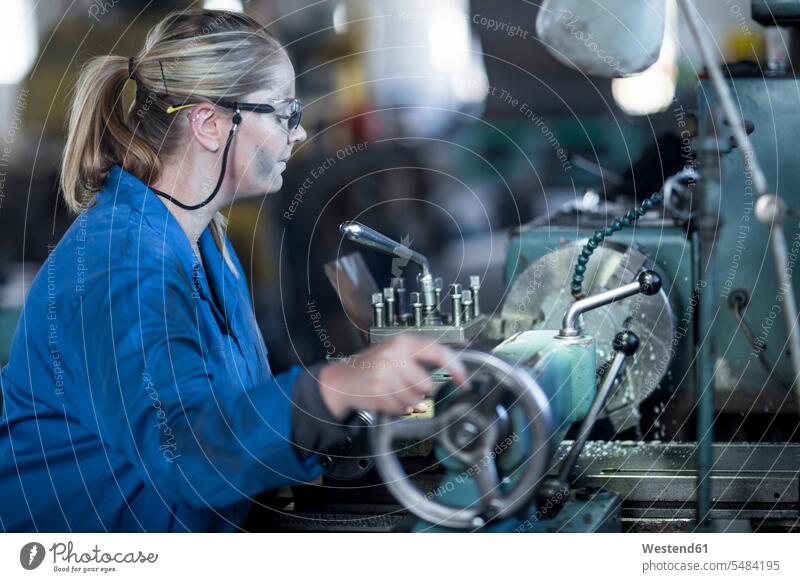 Frau bedient Maschine in der Werkstatt Werkstätte Werkstaette Werkstaetten Werkstätten arbeiten Arbeit Handwerk Gewerbe Industrie industriell Industrien