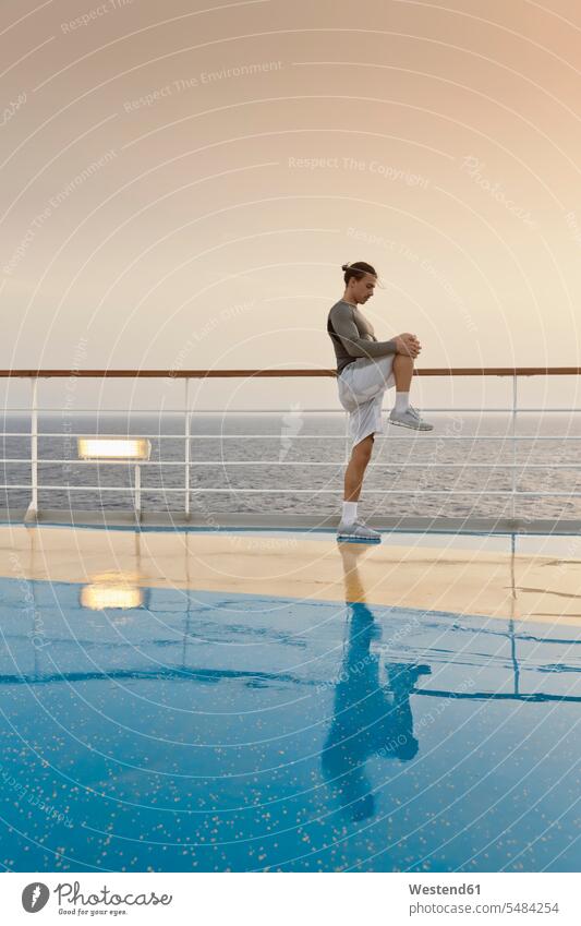 Junger Mann bei Übungen auf einem Schiffsdeck, Kreuzfahrtschiff, Mittelmeer an Bord Workout Sport Stretching dehnen strecken Dehnung stretchen Uebung Uebungen