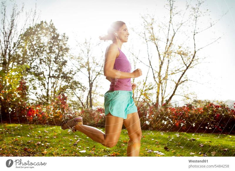 Frau joggt im herbstlichen Park trainieren laufen rennen weiblich Frauen Joggen Jogging Erwachsener erwachsen Mensch Menschen Leute People Personen Fitness fit