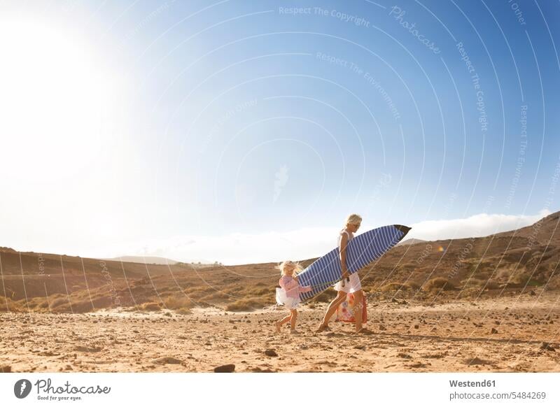 Spanien, Fuerteventura, Mutter und Tochter gehen mit Surfbrett am Strand spazieren Beach Straende Strände Beaches Surfbretter surfboard surfboards gehend geht