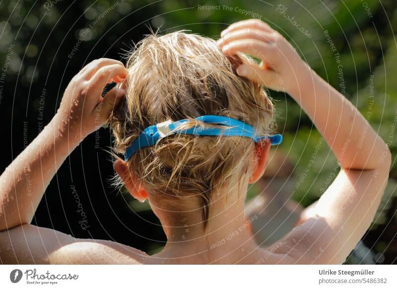Kind mit hellen Haaren setzt die Taucherbrille auf Urlaub mit Kindern Sommer schwimmen tauchen Pool Meer See Sonne blau blond kind Urlaub in Italien