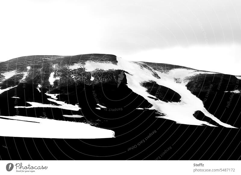 Schneeschmelze auf der Bergseite auf Island isländisch Formen abstrakt Schneeformen Islandbild Nordostisland Islandreise grau Himmelgrau Islandwetter