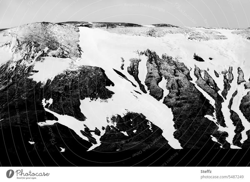 Blick auf eine Bergseite mit Schneeschmelze auf Island Schneeformen Hügelseite Formen Schneereste dunkel Nordisland nordisch düster Dunkelfärbung Einsamkeit
