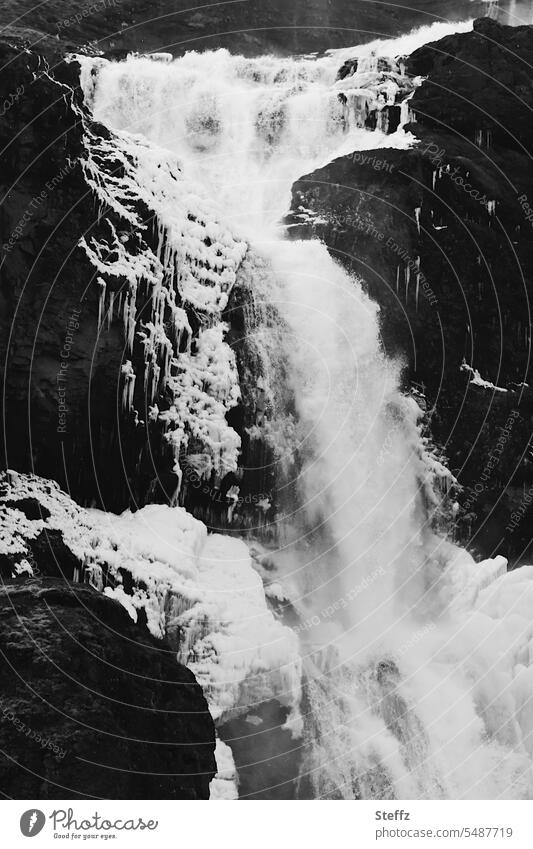 Wasserfallausschnitt auf Island isländisch Islandbild Eis vereist Islandreise kalt weiß schwarz frieren frierend strömen fließend Felsen Formen schwarzweiß