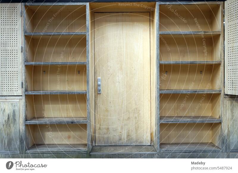 Holzverkleidung mit Holztür und leeren Regalen eines Kassenhäuschen aus hellem Naturholz am Schacht XII der Zeche Zollverein im Ruhrgebiet in Nordrhein-Westfalen in Deutschland