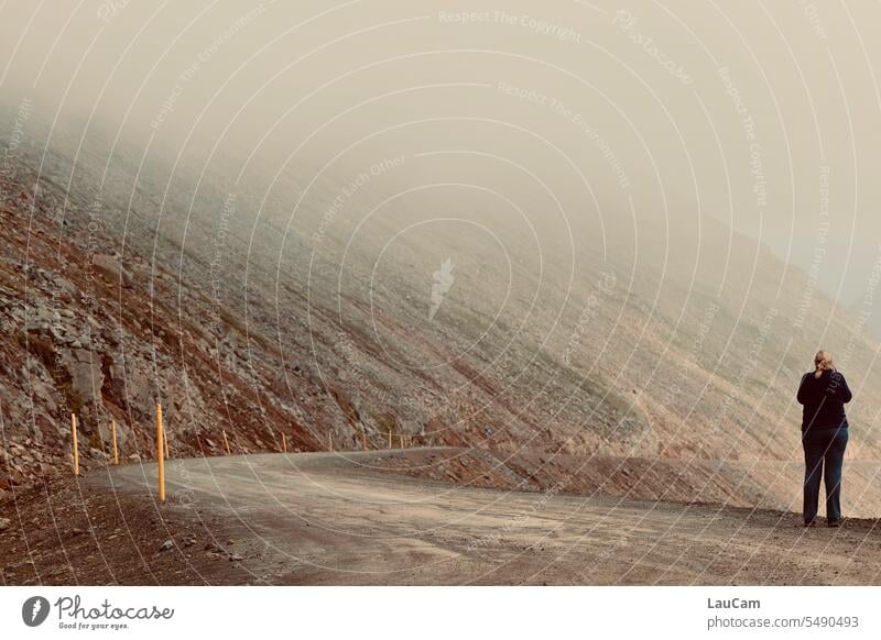 Kurve ins Nirgendwo Nebel Straße nebelig Person Frau Rückenansicht Nebelstimmung Blick nach vorn verhangen Wolken kein Weiterkommen blicken Landschaft Island