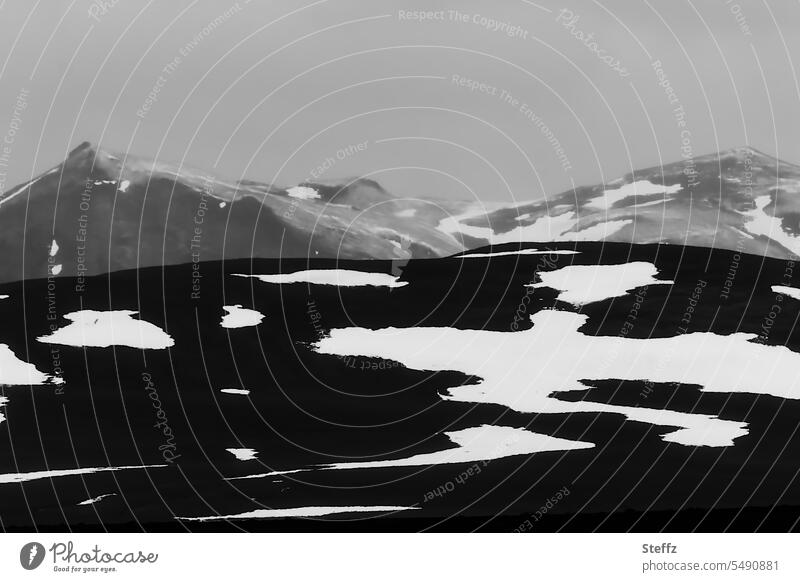 Berge mit Schneeschmelze auf Island isländisch Bergseite Schneeformen Schneereste abstrakt Formen geheimnisvoll dunkel mystisch karg rau schroff