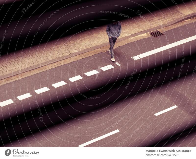 Durch die halboffenen Jalousien sieht man einen Mann über die Straße gehen straße beobachten streifen linien quer schräg mensch überqueren straßenfotografie