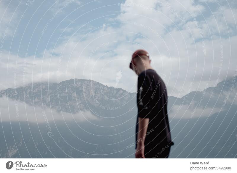 Mann steht vor Bergen am Gardasee Außenaufnahme Berge u. Gebirge Natur Landschaft Ferien & Urlaub & Reisen Himmel Wolken