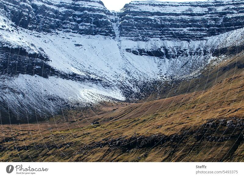 Färöer Insel mit einem kleinen Häuschen Färöer Inseln Schafsinseln Färöerinseln Färöer-Inseln Felseninsel schneebedeckt Schnee Schneeschmelze Schneeschichten