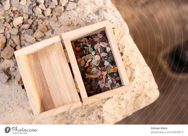 Bodenschätze liegen in einer kleinen Holzkiste Fundstücke bunt Edelsteine selten Schatzkiste wertvoll ideell Wertschätzung sammeln spielen Ausgrabung