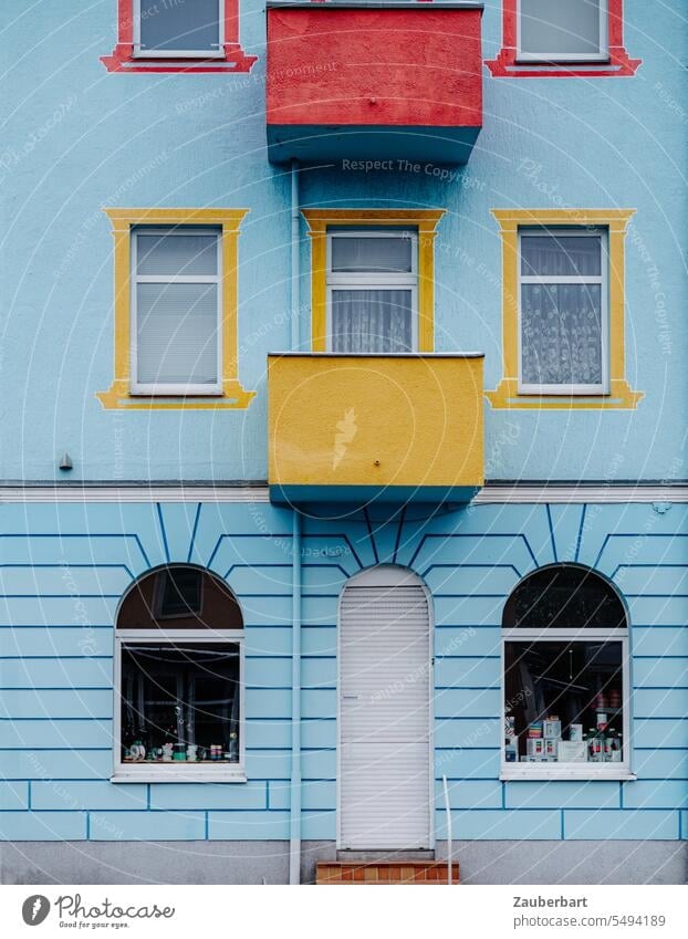 Blaue Hausfassade der Gründerzeit mit farbigen Balkonen und Fensterrahmen Fassade blau symmetrisch gelb rot Bullerbü schmuck bunt Sanierung Farbe wohnen