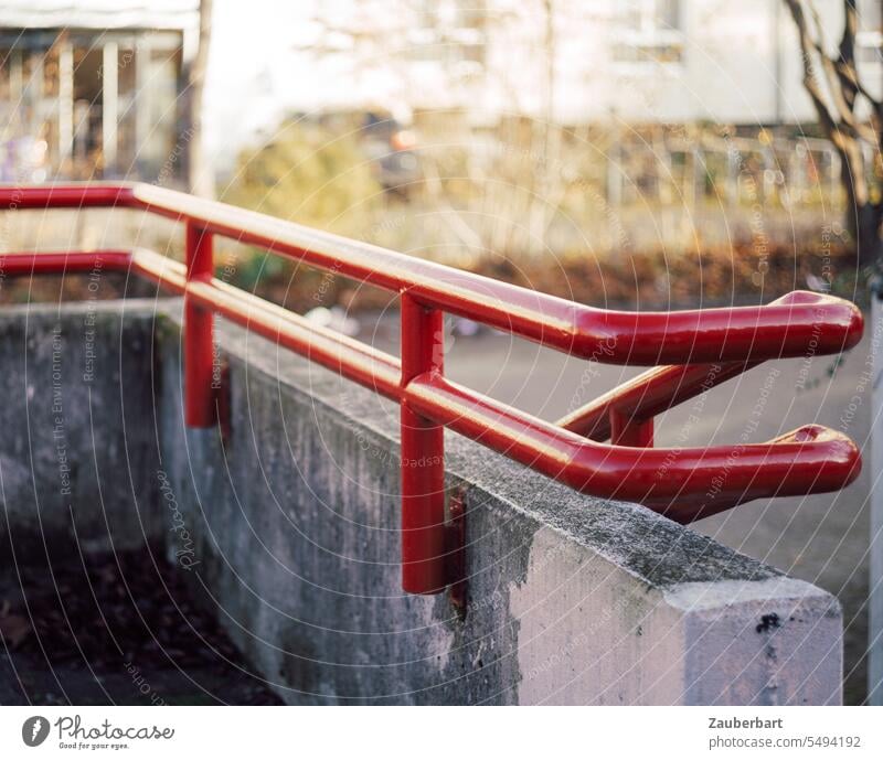 Rotes Geländer, Handlauf aus den 70er Jahren, Beton und Kurve rot Stahl Schwung Betonwand Architektur architektonisch festhalten Griff griffig Halt Stütze