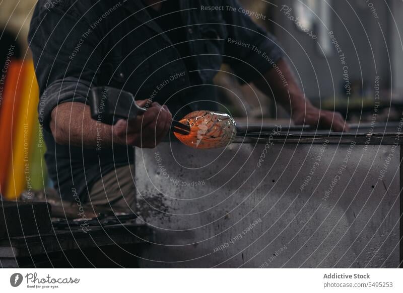 Unbekannter Handwerker mit Glasbläser in der Werkstatt Mann Glaswerkstatt Kunstgewerbler geschmolzen handgefertigt Gerät professionell Kunsthandwerker Design