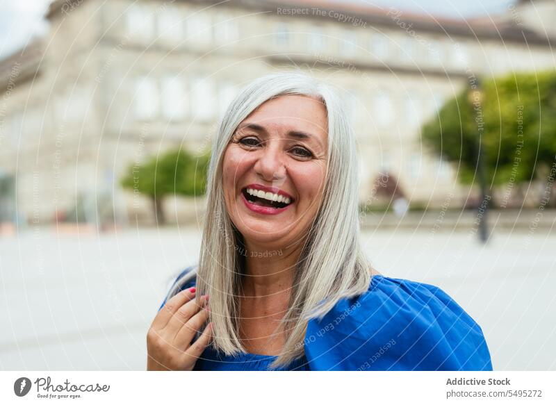 Lächelnde Frau auf der Straße in der Stadt positiv Großstadt Glück froh heiter Optimist modern Freude zufrieden älter Senior genießen Inhalt angenehm Vergnügen