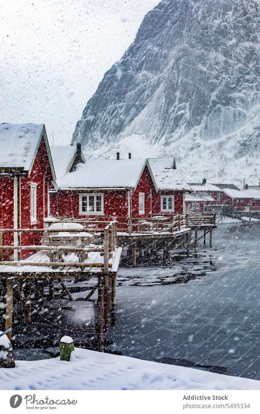 Kleines Dorf am verschneiten Seeufer Haus Wohnsiedlung Winter Schnee Fluss Berge u. Gebirge majestätisch Landschaft Norwegen Lappland lofoten Insel Norden