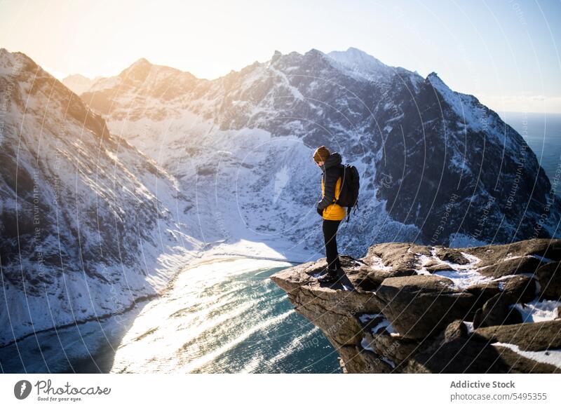 Reisender steht auf einer Klippe vor den Bergen Berge u. Gebirge Tourist felsig Wanderung Formation Aussichtspunkt Trekking Saum lofoten Insel Norwegen