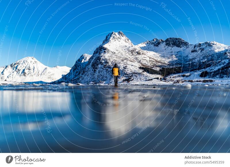 Niedriger Winkel Reisende stehen auf gefrorenen See in der Nähe von verschneiten Bergen Reisender Tourist Berge u. Gebirge Winter Schnee Natur lofoten Insel