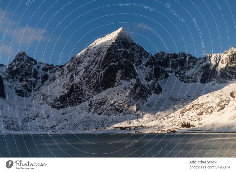 Verschneite Berge in Meeresnähe an einem Wintertag unter Himmel Berge u. Gebirge MEER Insel Landschaft Schnee Natur felsig Gipfel malerisch lofoten Norwegen
