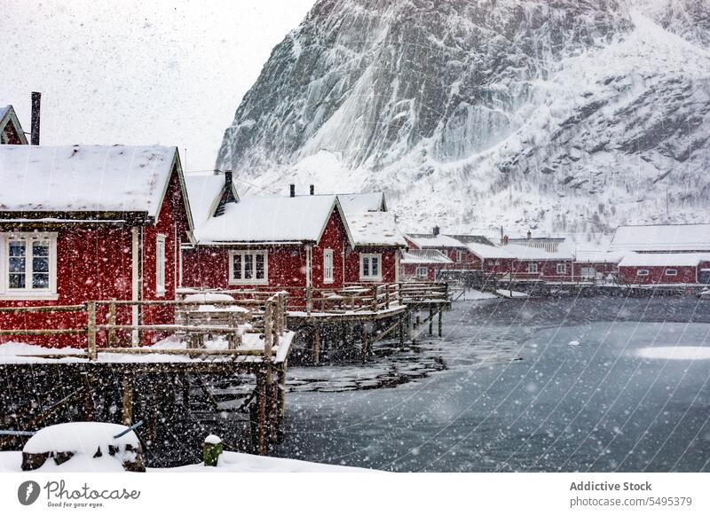 Kleines Dorf am verschneiten Seeufer Haus Wohnsiedlung Winter Schnee Fluss Berge u. Gebirge majestätisch Landschaft Norwegen Lappland lofoten Insel Norden
