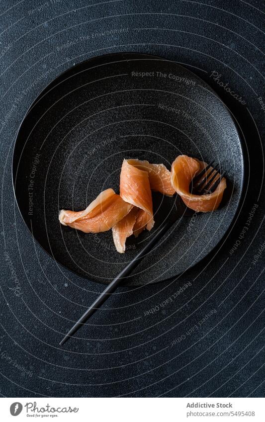 Gesunder Lachs in Scheiben auf dunklem Teller Speise Gesundheit Lebensmittel schwarz dunkel Vor dunklem Hintergrund Tisch Oberfläche lecker frisch Ernährung