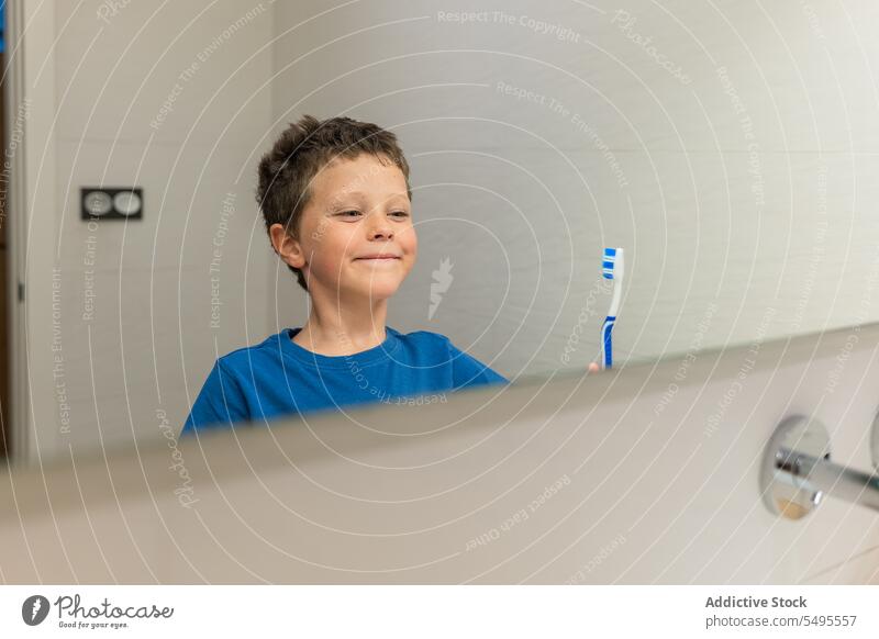 Junge schaut in den Spiegel im Badezimmer Kind Bürste Zahnbürste Hygiene täglich Routine mündlich Personal heimisch Pflege Morgen heimwärts dental Sauberkeit