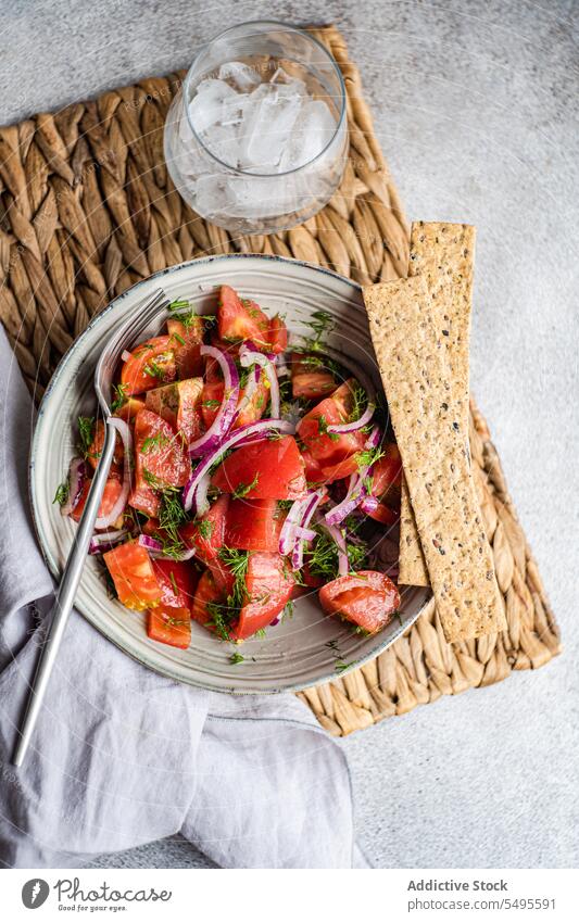 Schüssel mit Salat, knusprigem Brot und Glas mit Eis Salatbeilage knuspriges Brot Schalen & Schüsseln Tomate Zwiebel Kraut Bestandteil frisch Vegetarier