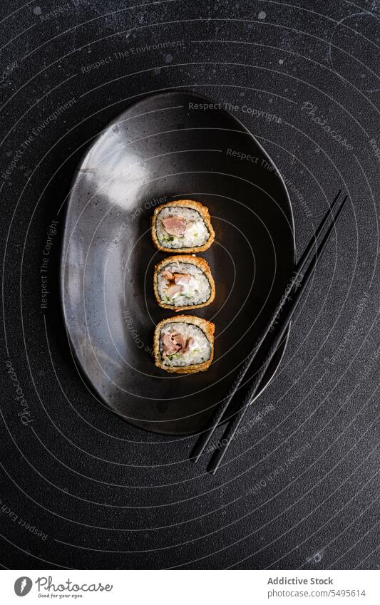 Leckere gebratene Sushi-Rollen auf einem Teller im Restaurant rollen gebratenes Sushi Lachs Avocado Asiatische Küche Reis Mittagessen Mahlzeit Speise lecker