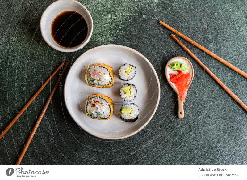 Draufsicht auf japanisches Essen auf einem weißen Betontisch dienen Kulisse Sushi rollen Schalen & Schüsseln Lachs Reis Seegras Sojasauce Asiatische Küche