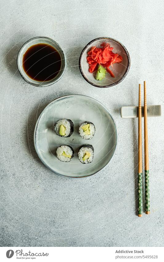 Draufsicht auf japanisches Essen auf einem weißen Betontisch dienen Kulisse Sushi rollen Schalen & Schüsseln Lachs Reis Seegras Sojasauce Asiatische Küche