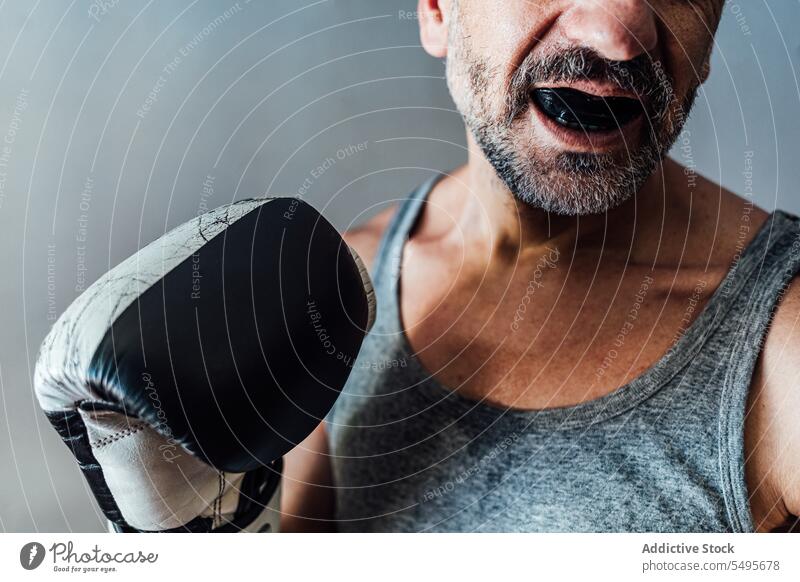 Erwachsener Kropf Mann mit doppelter Zahnspange Mundschutz Boxer Mund geöffnet maskulin brutal selbstbewusst bewachen Vorschein männlich Persönlichkeit Wand