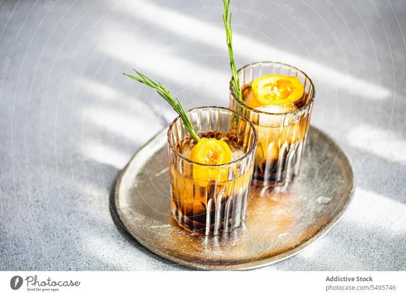 Pikante Margarita-Cocktails trinken Glas durchsichtig liquide braun Getränk Alkohol alkoholisch Eis Würfel Tablett Scheibe Frucht frisch grün Blatt grau Tisch