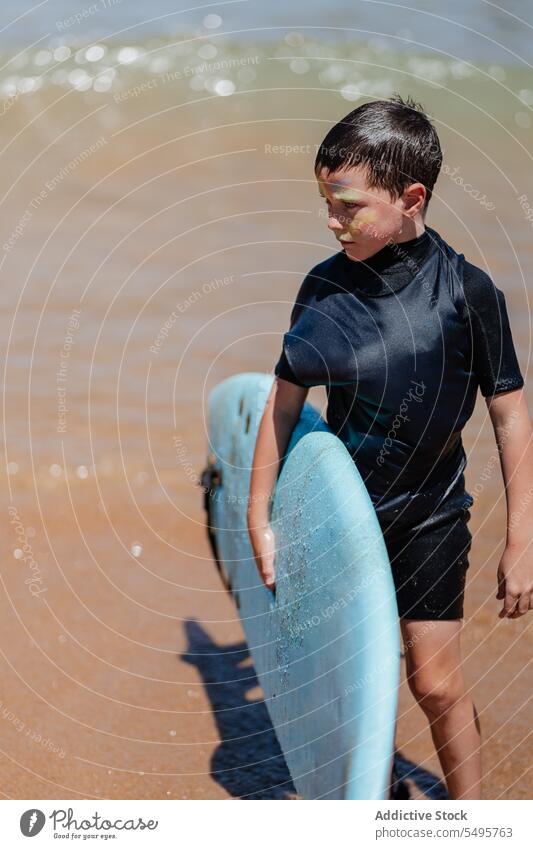 Junge mit Surfbrett im Meer Kind Surfer MEER Aktivität Wasser seicht Hobby Sommer Natur genießen Urlaub sportlich Strand Feiertag Lifestyle Gesichtsfarbe aktiv