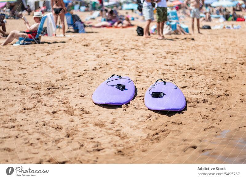 Aufblasbare Bodyboards am Sandstrand mit einer Gruppe von Menschen aufblasbar sandig Ufer Seeküste Strand sich[Akk] entspannen Sonnenbad Urlaub Menschengruppe