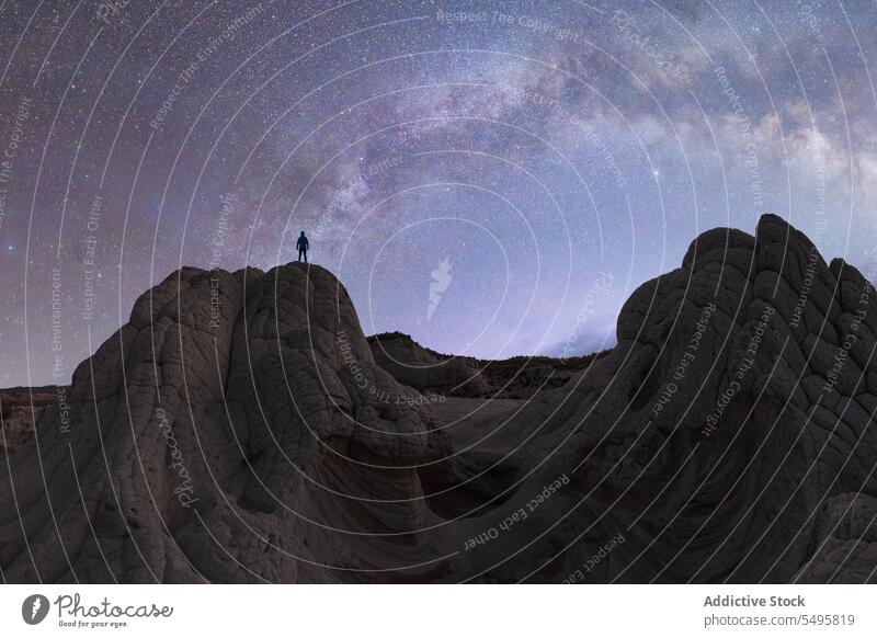 Anonyme Person auf Felsformation in Tal unter Sternenhimmel Tourist Felsen Formation Himmel taveler sternenklar bewundern wüst Silhouette Nacht erkunden