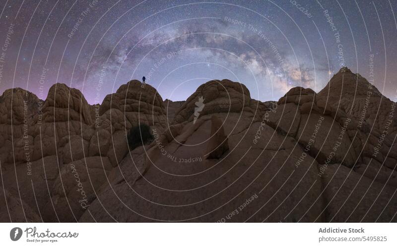 Anonyme Person auf Felsformation in Tal unter Sternenhimmel Tourist Felsen Formation Himmel taveler sternenklar bewundern wüst Silhouette Nacht erkunden