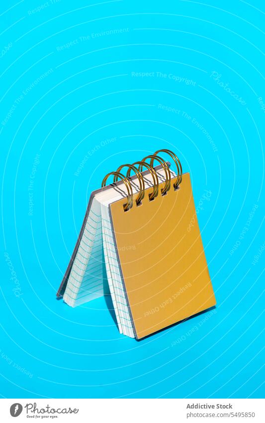 Gelbes Hardcover-Notizbuch mit Spiralbindung auf blauem Hintergrund Spirale fesseln Notebook Page Papier Linie Information Buch Stock Notizblock Memo kreativ
