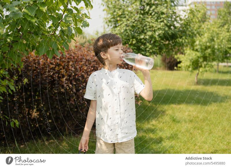 Durstiger Junge trinkt im Park Wasser aus einer Flasche trinken durstig Sommer Kind Augen geschlossen Pflanze Wochenende Lifestyle niedlich Kinder Natur
