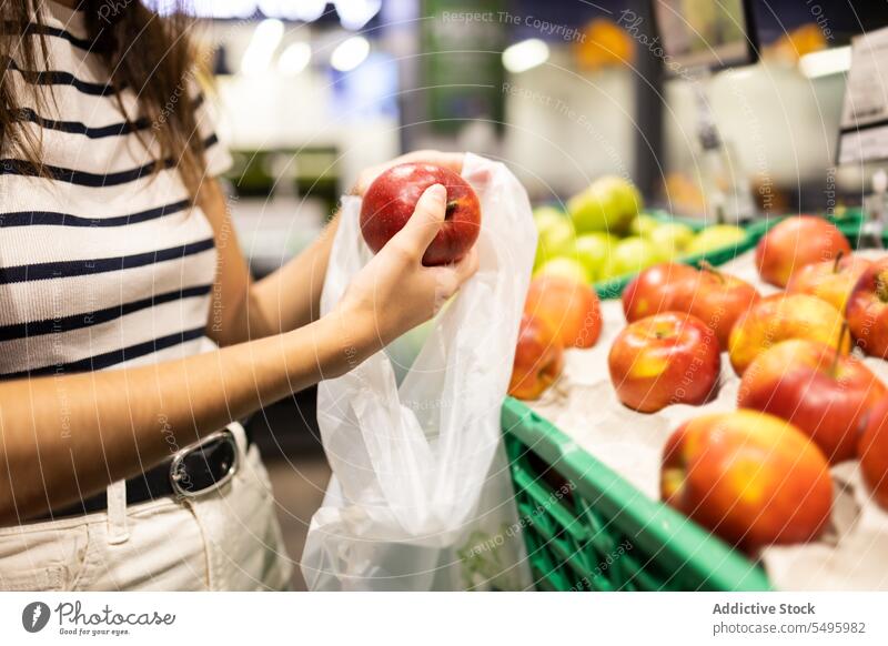 Crop-Frau beim Aussuchen von Äpfeln im Lebensmittelladen Apfel wählen kaufen setzen Markt Lebensmittelgeschäft Frucht Tasche Kauf Kunde frisch organisch reif