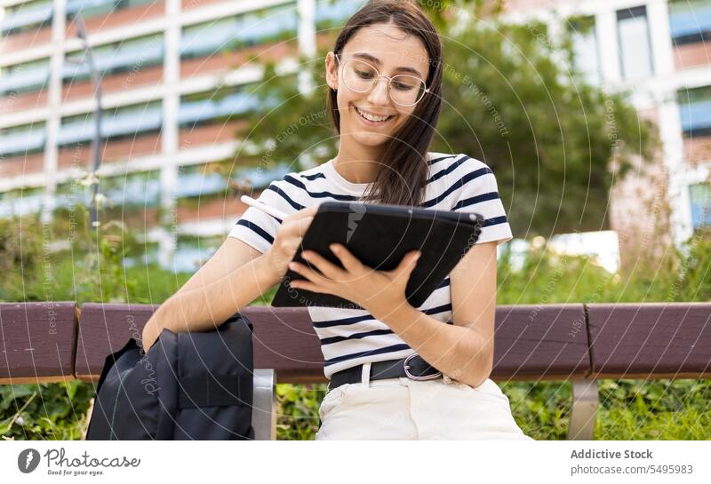 Junge Frau benutzt Tablet auf der Straße Tablette benutzend schreiben Glück Lächeln modern Großstadt Apparatur Gerät Brille jung Zeitgenosse positiv Anschluss