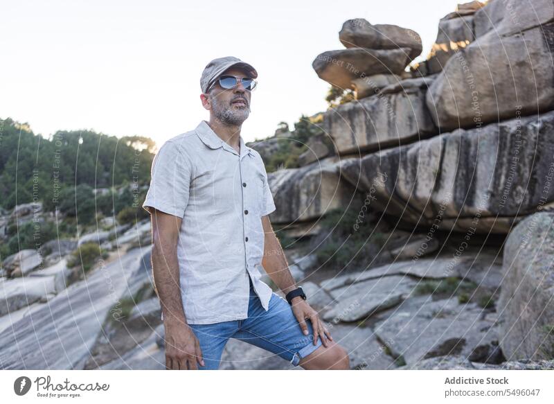 Ernster Mann mit Sonnenbrille auf felsigem Terrain stehend Natur ernst Abend Sommer Felsen Umwelt reisen natürlich männlich Verschlussdeckel Vollbart