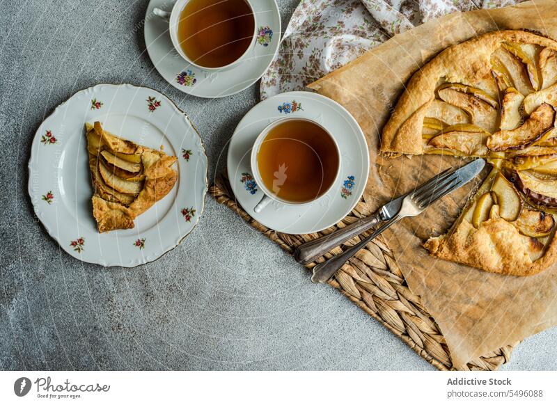 Apfelgalette und Tee auf dem modernen Betontisch Pasteten Spielfigur Galette Tasse Teetasse rustikal Tablett grau Tisch Lebensmittel trinken Getränk liquide